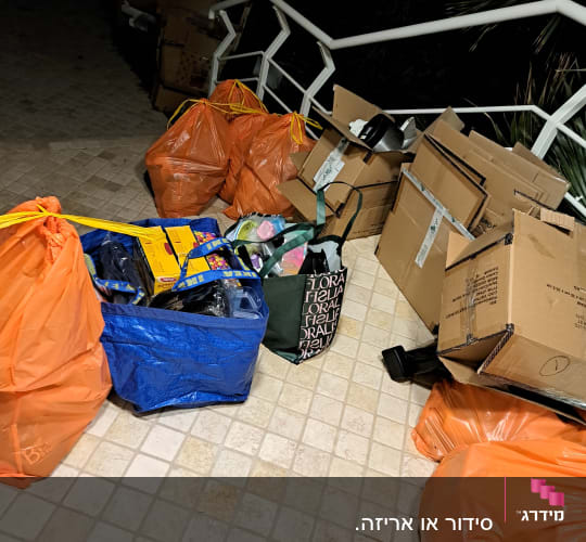 שקיות וקרטונים על רצפה ליד מדרגות